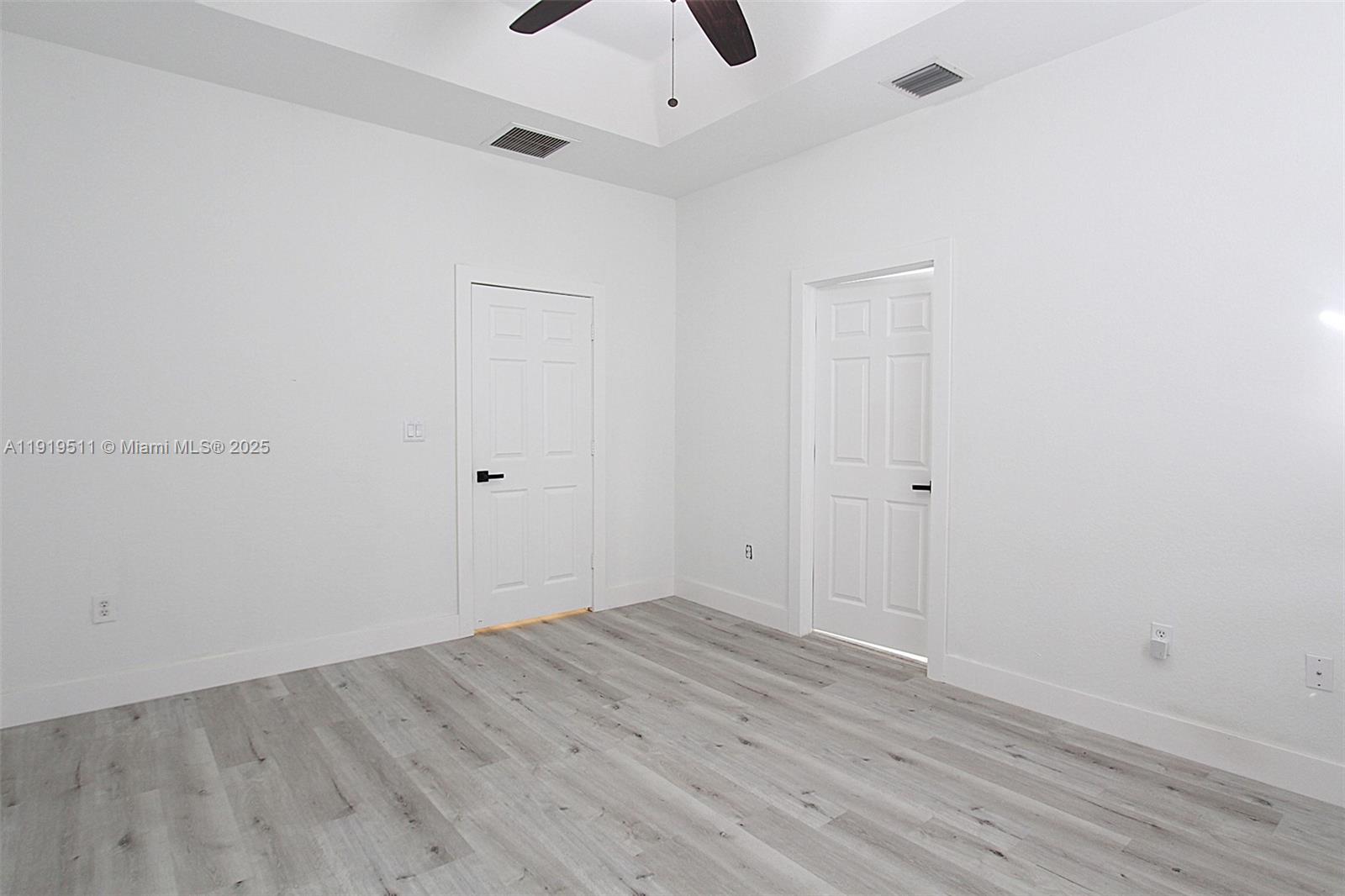 9390 Southwest 222nd Way, Unit 9390 Cutler Bay, FL 33190 - Photo 17 of 32 an empty room with wooden floor and ceiling fan