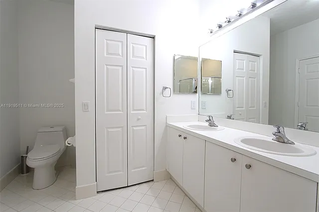 a spacious bathroom with a toilet a sink a mirror and a shower