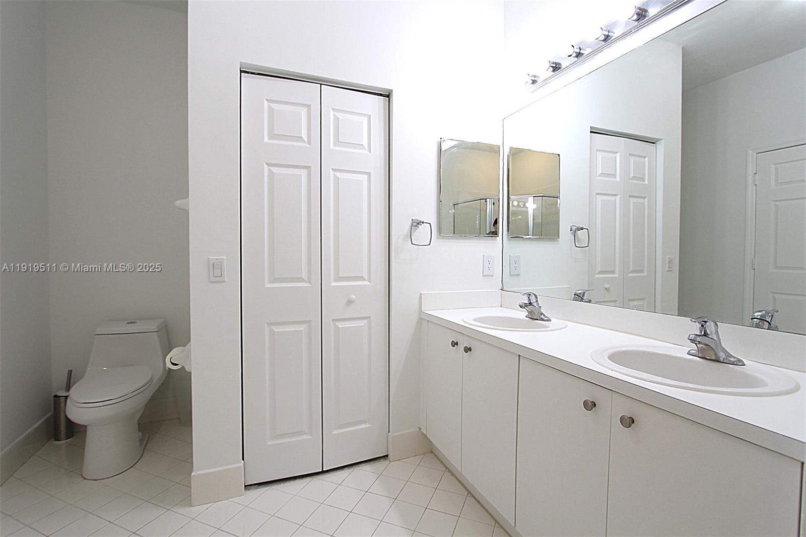 9390 Southwest 222nd Way, Unit 9390 Cutler Bay, FL 33190 - Photo 21 of 32 a spacious bathroom with a toilet a sink a mirror and a shower