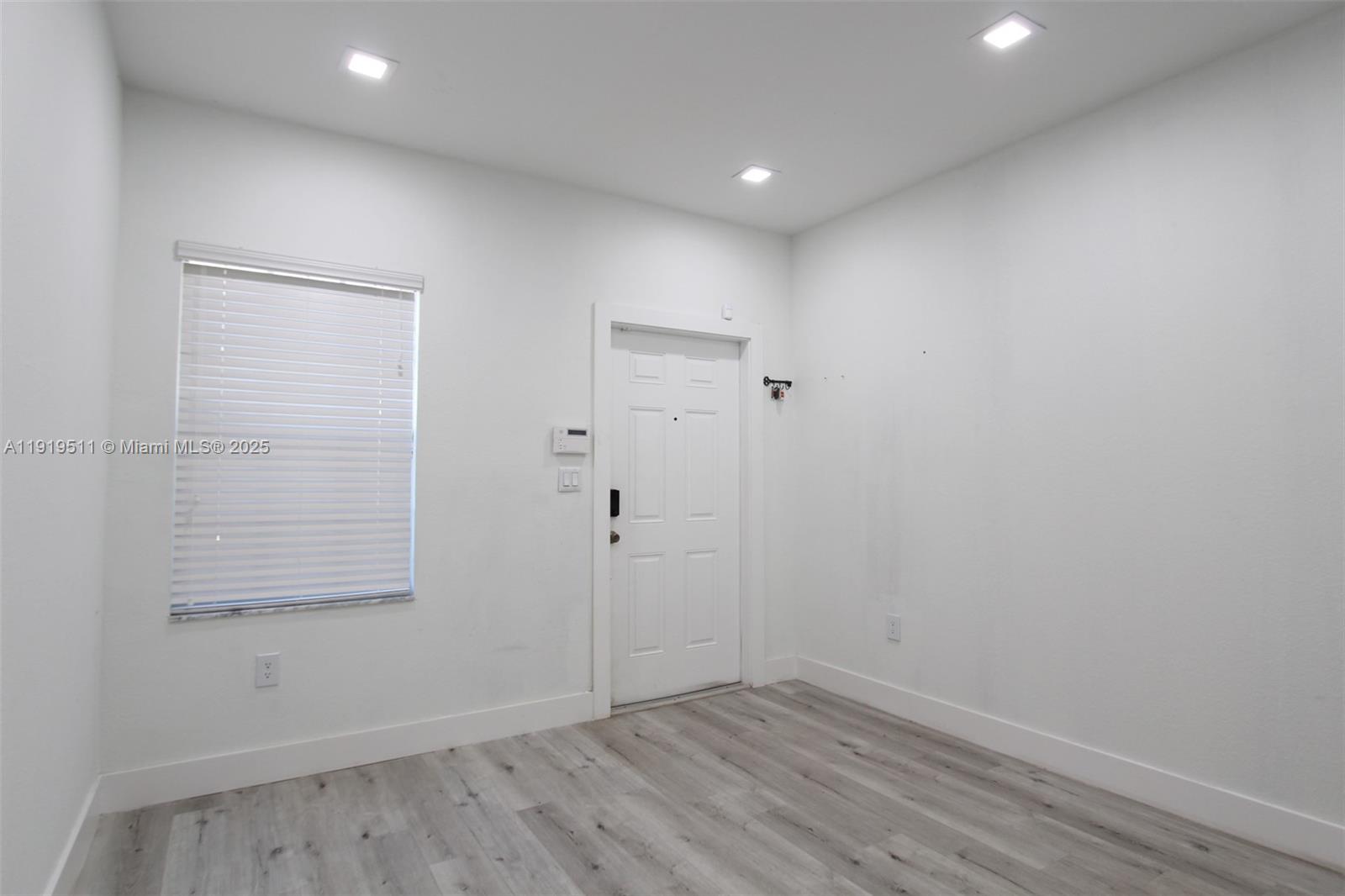 9390 Southwest 222nd Way, Unit 9390 Cutler Bay, FL 33190 - Photo 3 of 32 an empty room with wooden floor and windows