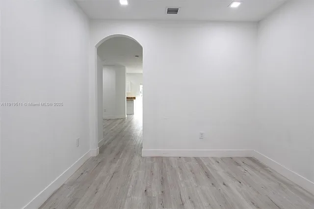 a view of a room with wooden floor and a window