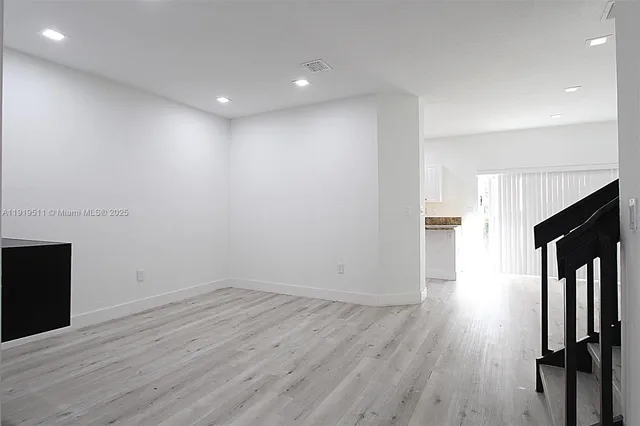 an empty room with wooden floor and fireplace