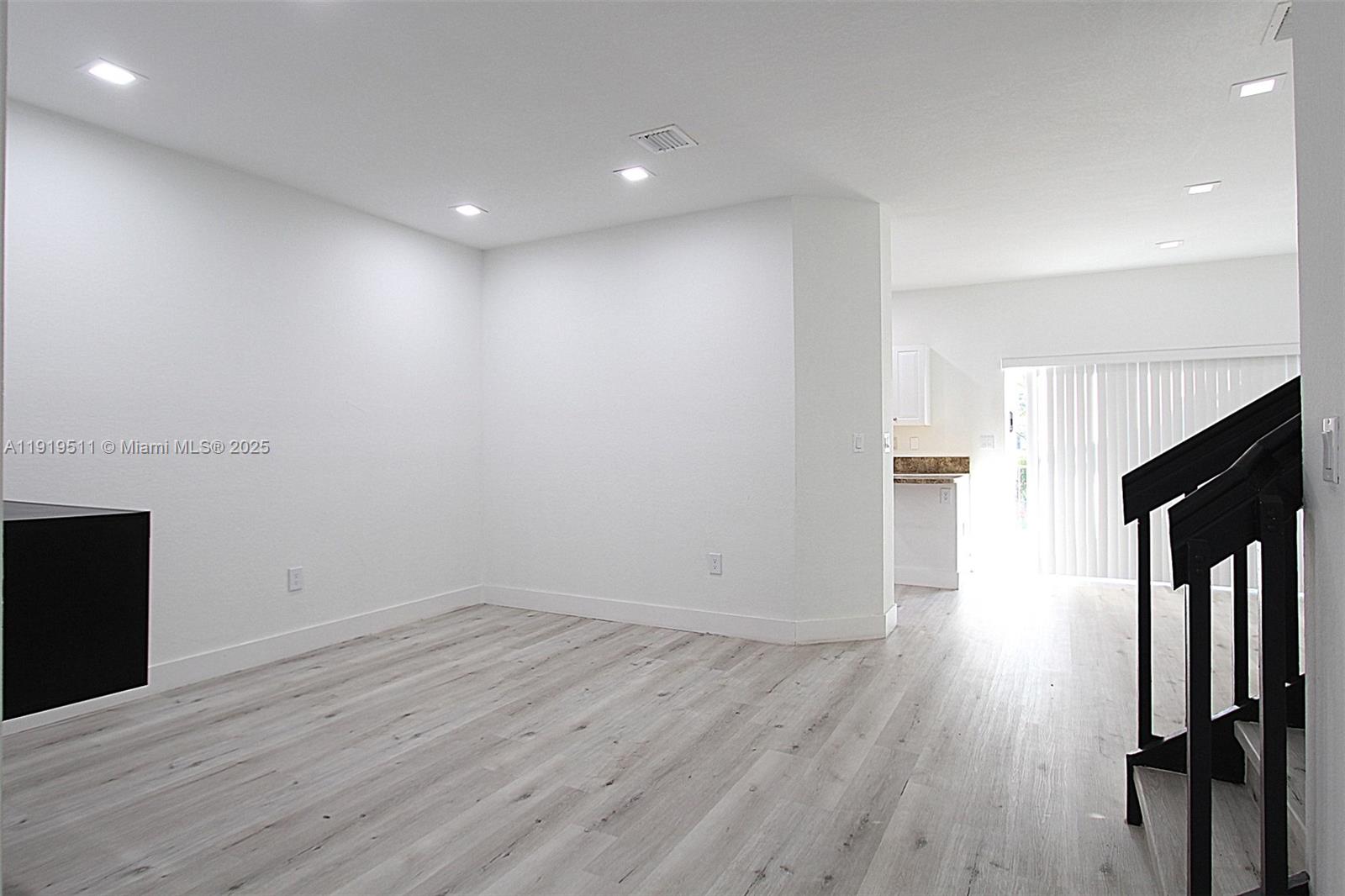 9390 Southwest 222nd Way, Unit 9390 Cutler Bay, FL 33190 - Photo 5 of 32 an empty room with wooden floor and fireplace