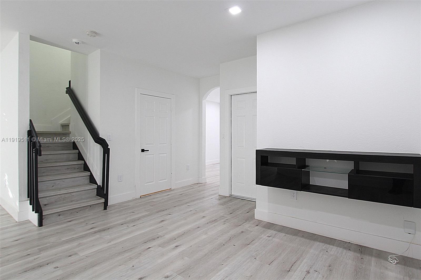 9390 Southwest 222nd Way, Unit 9390 Cutler Bay, FL 33190 - Photo 8 of 32 a view of an empty room with wooden floor and stairs