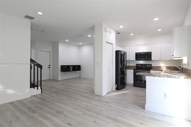 a kitchen with stainless steel appliances granite countertop a refrigerator and a stove top oven