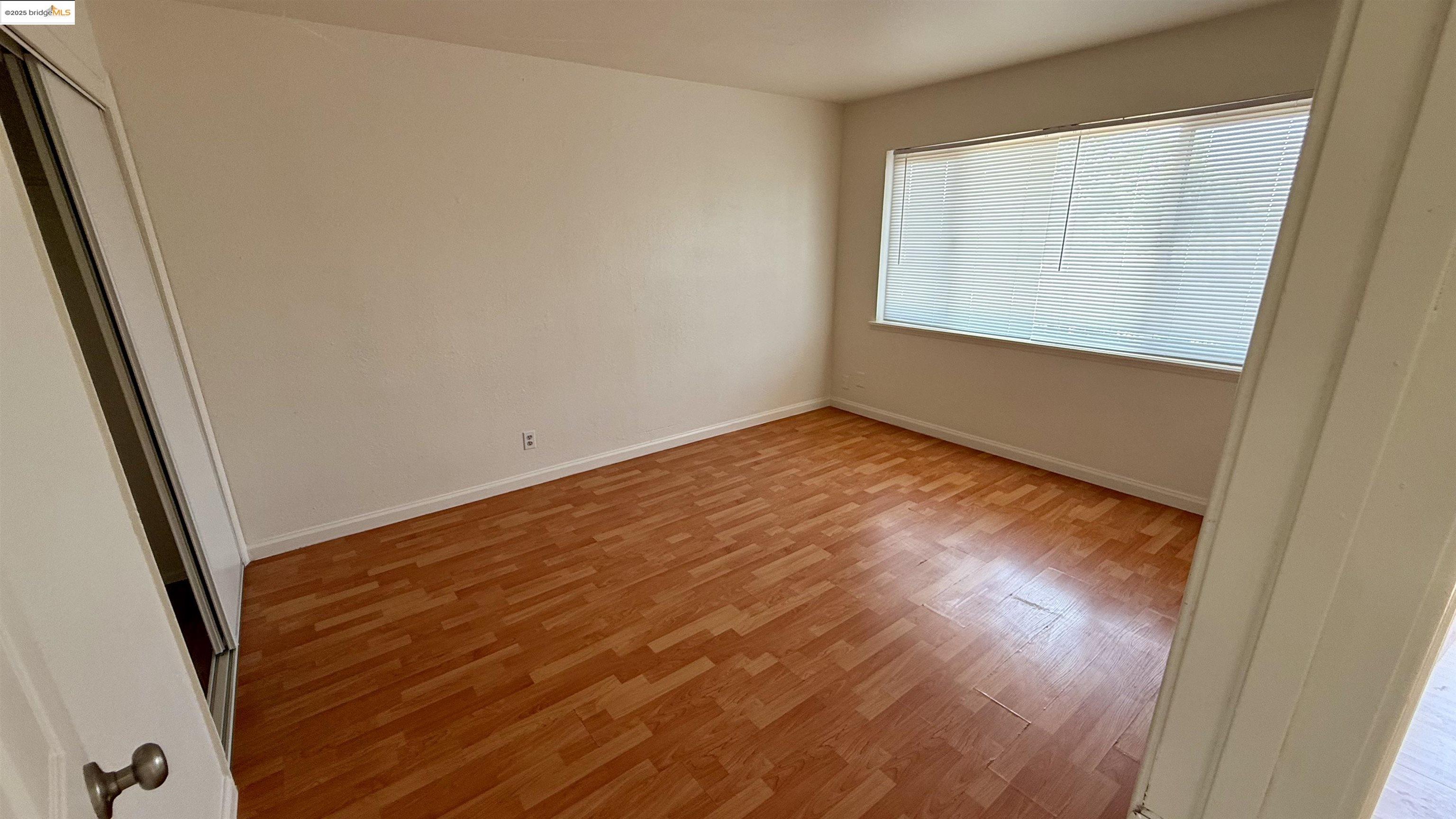 10100 Walnut Street, Unit 3 Oakland, CA 94603 - Photo 5 of 11 an empty room with wooden floor and windows