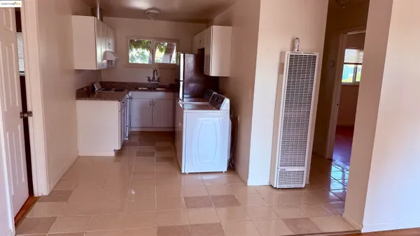 a view of a kitchen with fridge and wooden floor