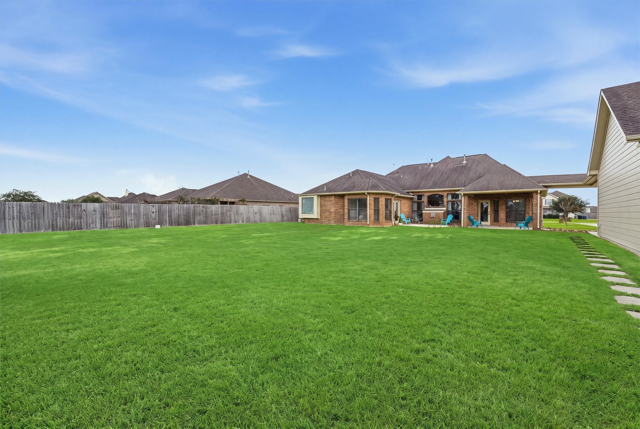4810 Magnolia Bend Drive Rosharon, TX 77583 - Photo 29 of 40 Backyard features a lush, green lawn and a spacious patio area, perfect for outdoor entertaining and relaxation.