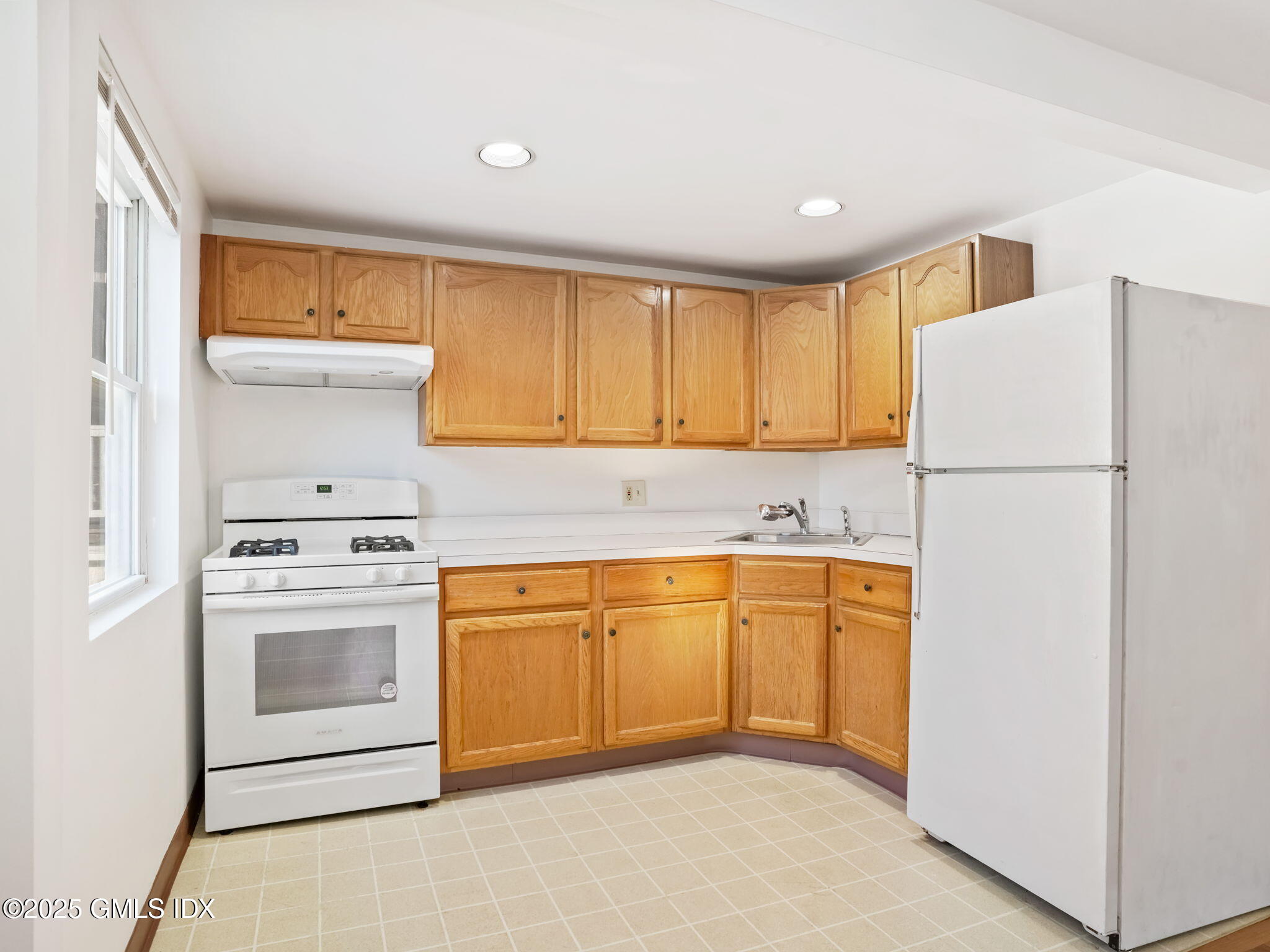28 Orchard Place, Unit 2 Greenwich, CT 06830 - Photo 7 of 13 a kitchen with stainless steel appliances granite countertop a refrigerator sink and white cabinets