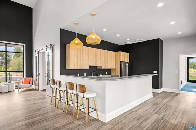 a kitchen with stainless steel appliances a microwave a stove a sink dishwasher and a refrigerator with wooden floor