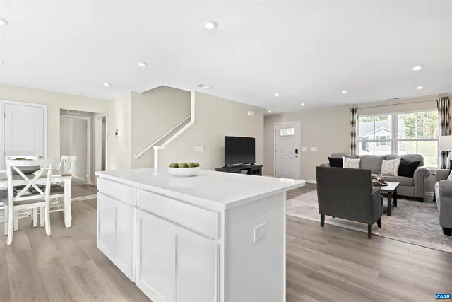 a living room with furniture a wooden floor and a flat screen tv