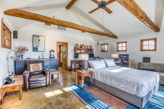 a spacious bedroom with a bed a couch and dresser