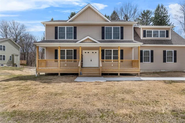 a view of a white house with large windows next to a yard