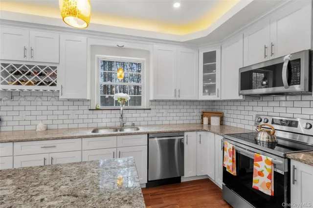 a open kitchen with kitchen island a sink dishwasher stove with wooden floor