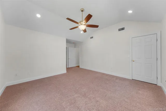 an empty room with fan and windows