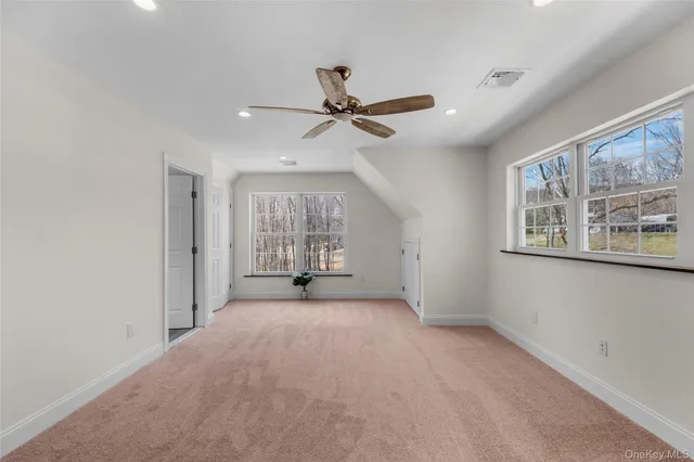 a spacious bedroom with a bed couch chandelier and a window
