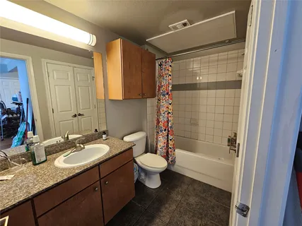a bathroom with a granite countertop sink toilet and shower