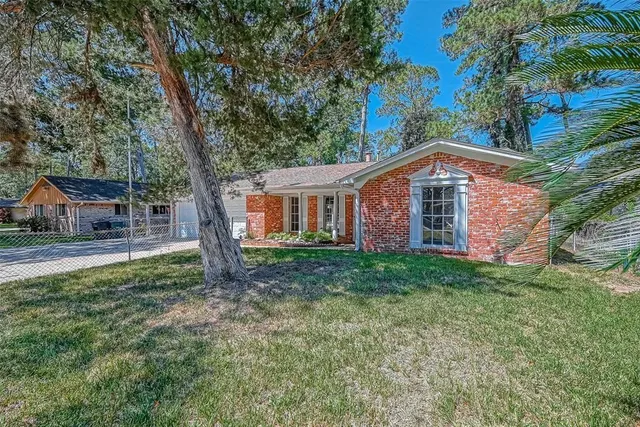 a front view of a house with yard and green space