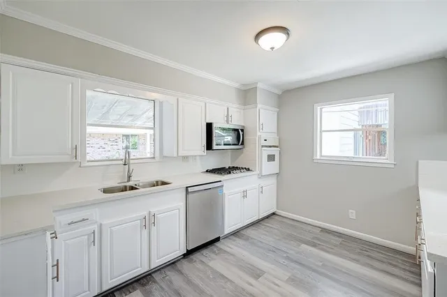 a kitchen with appliances a sink and a window
