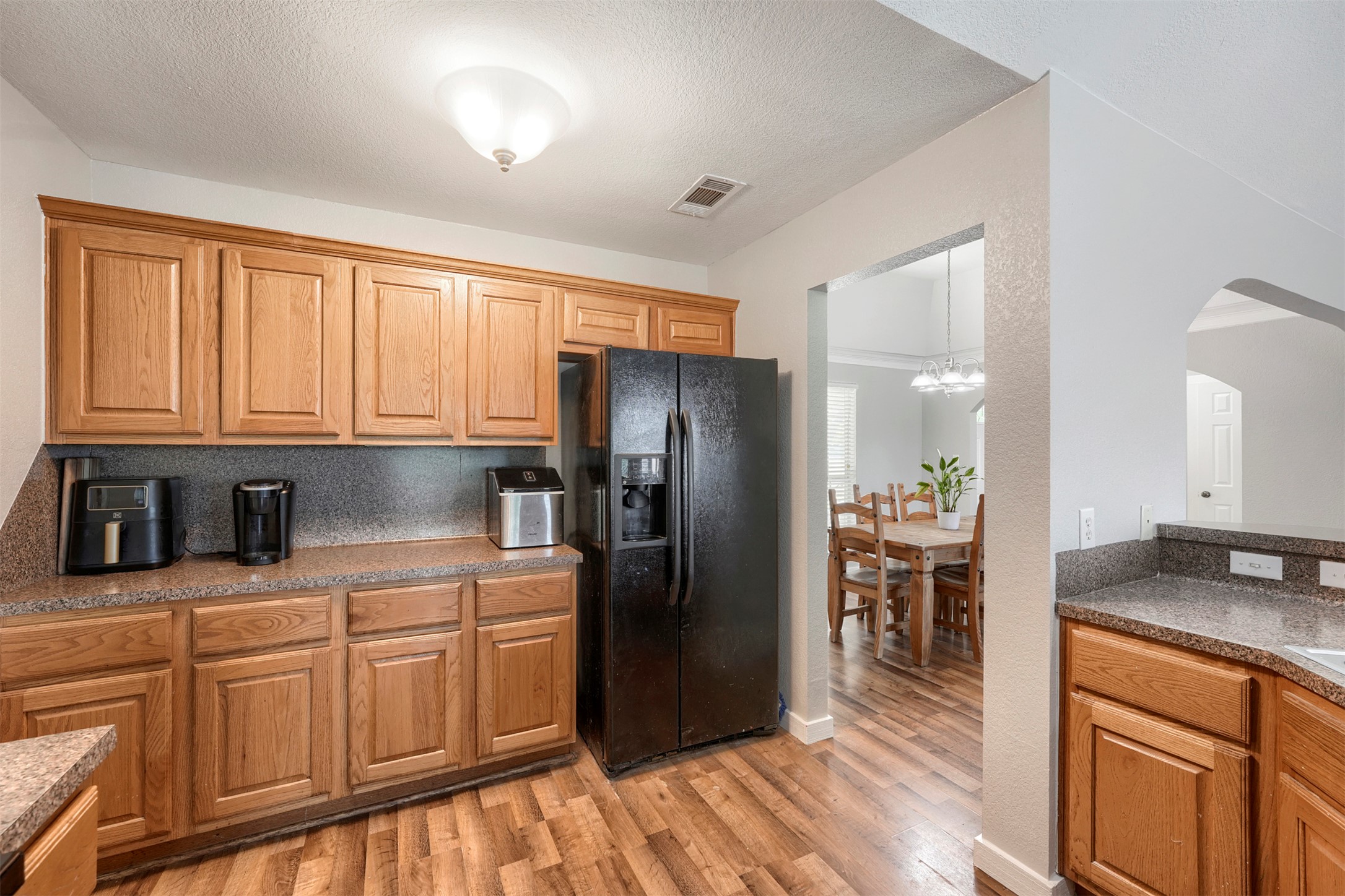 1105 2nd Street Jarrell, TX 76537 - Photo 11 of 27 A well-equipped kitchen boasts durable laminate flooring and ample wood cabinetry.