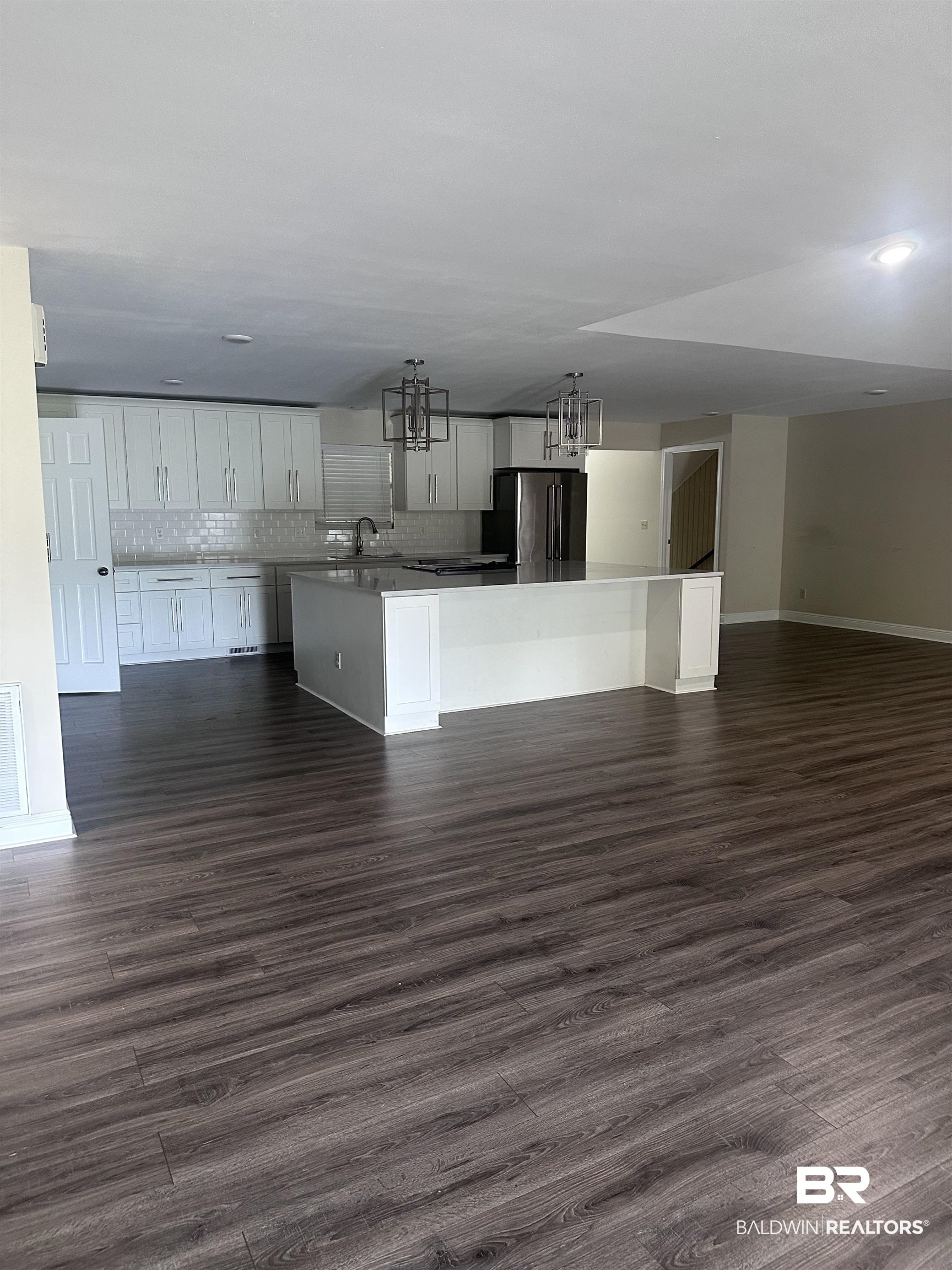 2785 Sowell Road Brewton, AL 36426 - Photo 24 of 24 Kitchen featuring a kitchen island with sink, open floor plan, backsplash, and dark wood-style flooring