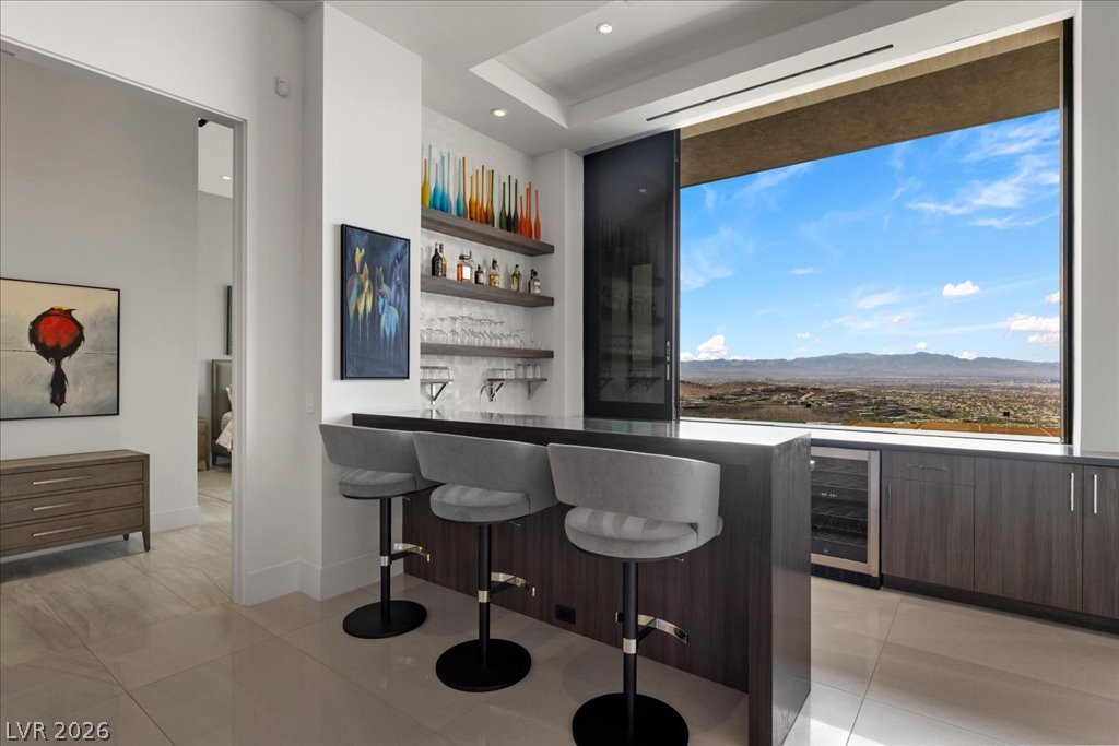 657 Ridgestone Rim Court Henderson, NV 89012 - Photo 40 of 97 Floor-to-ceiling glass framing panoramic desert views defines this sleek custom wet bar.