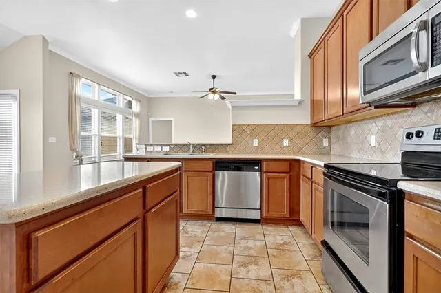 a kitchen with stainless steel appliances granite countertop a refrigerator sink stove and microwave