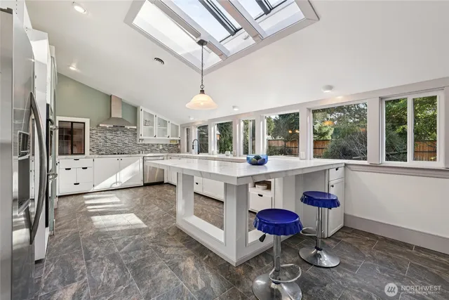 a kitchen with stainless steel appliances kitchen island granite countertop a stove and cabinets
