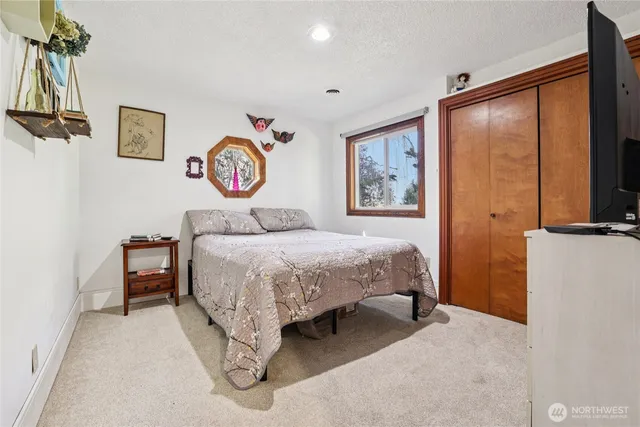 a bedroom with a bed and a wall painting