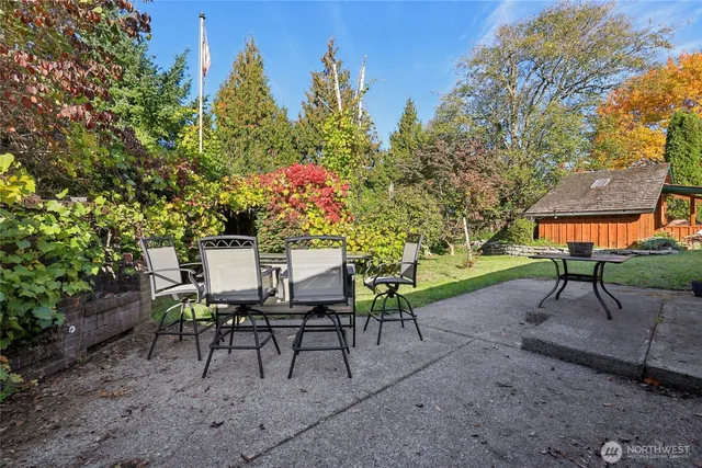 a view of a chairs and table in backyard
