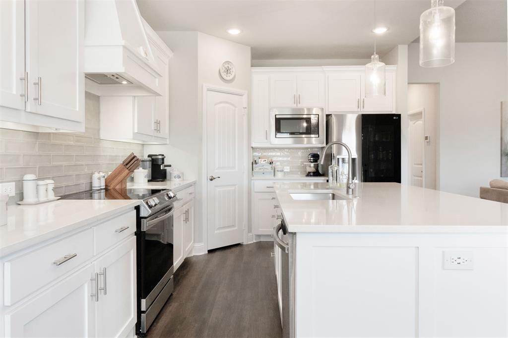 849 County Road 4764 Boyd, TX 76023 - Photo 12 of 40 a kitchen with kitchen island white cabinets and stainless steel appliances