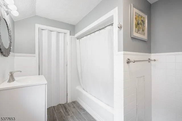 a bathroom with a bathtub a sink and a mirror