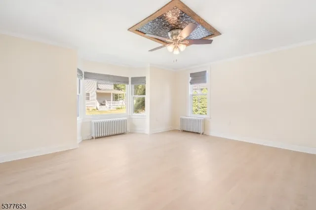 an empty room with windows and cabinet