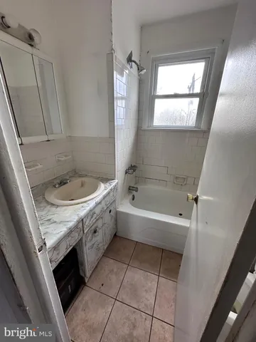 a bathroom with a tub sink and mirror