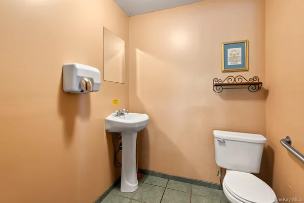 a bathroom with a toilet sink and mirror