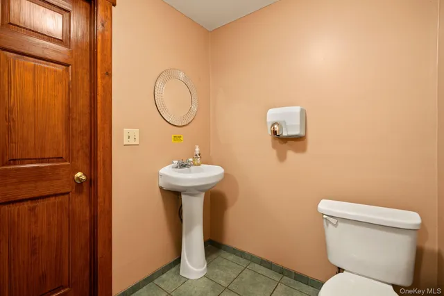 a bathroom with a toilet sink and mirror