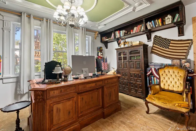 a view of a workspace with furniture and a window