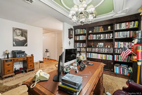 a view of a workspace with furniture and a book shelf