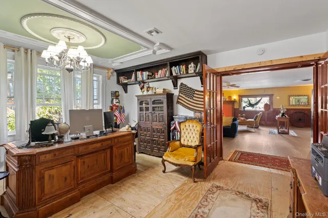 a living room with furniture a chandelier and a fireplace