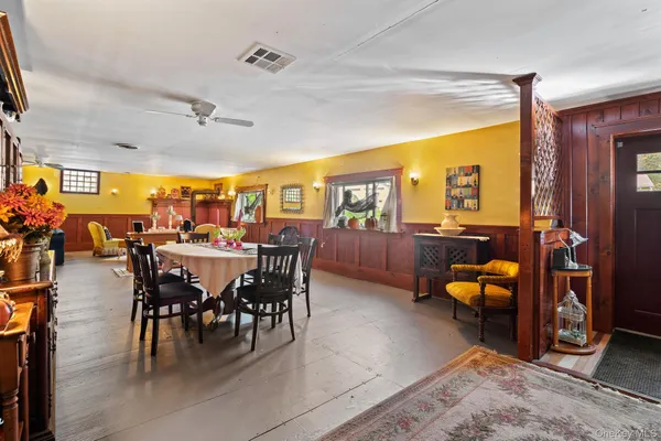 a view of a dining room and livingroom with furniture a rug a fireplace and a chandelier