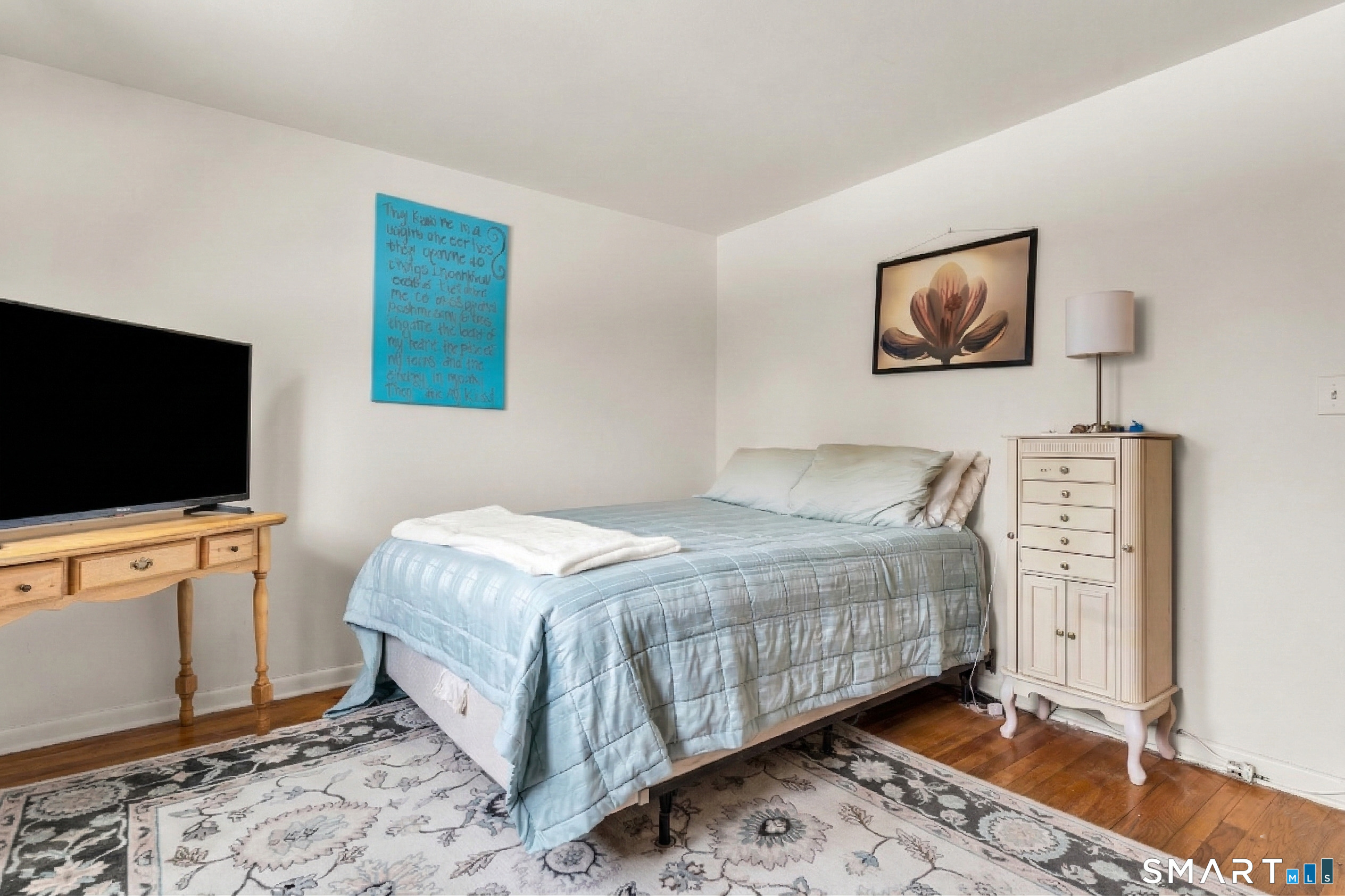 144 East Main Street, Unit 5 Clinton, CT 06413 - Photo 11 of 19 a bedroom with a bed and a flat screen tv