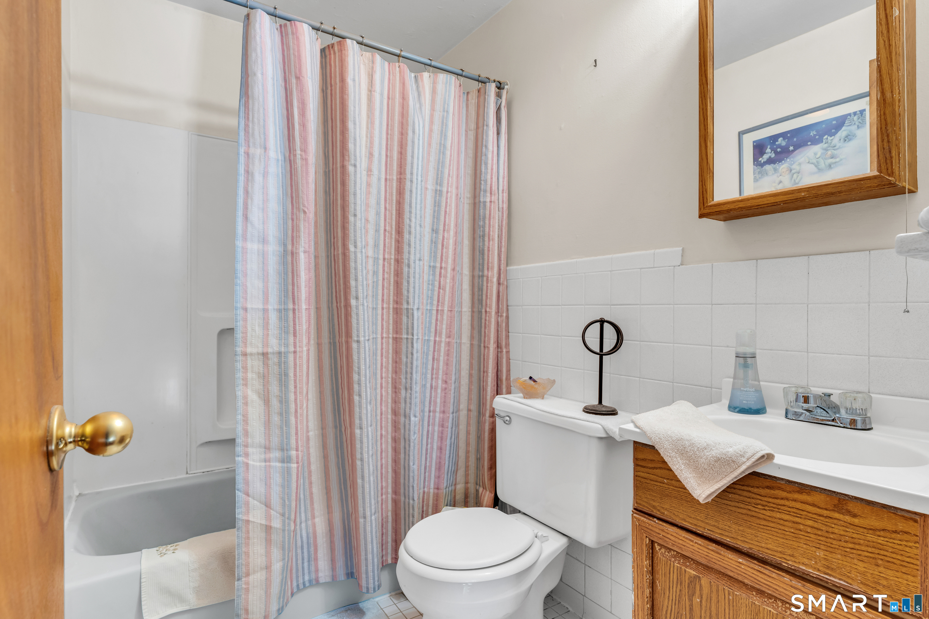 144 East Main Street, Unit 5 Clinton, CT 06413 - Photo 15 of 26 a bathroom with a sink a toilet and shower curtain