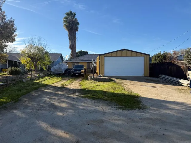 a view of a house with backyard and sitting area