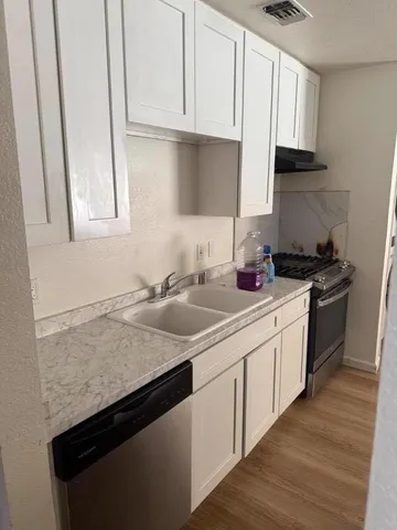 a kitchen with stainless steel appliances granite countertop a sink stove and cabinets