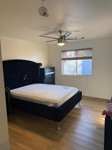 a bedroom with a bed and wooden floor