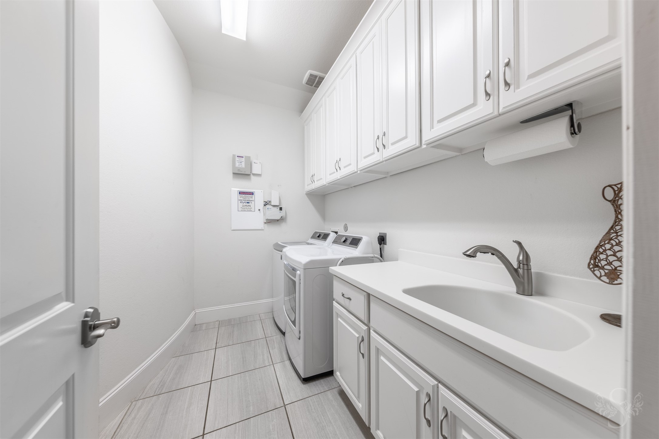 28602 Hoffman Spring Lane Fulshear, TX 77441 - Photo 25 of 49 Spacious utility room offers abundant cabinetry, a deep utility sink, and ample counter space for folding and organization. Designed for convenience, this laundry area adds flexibility to the home’s thoughtful layout.
