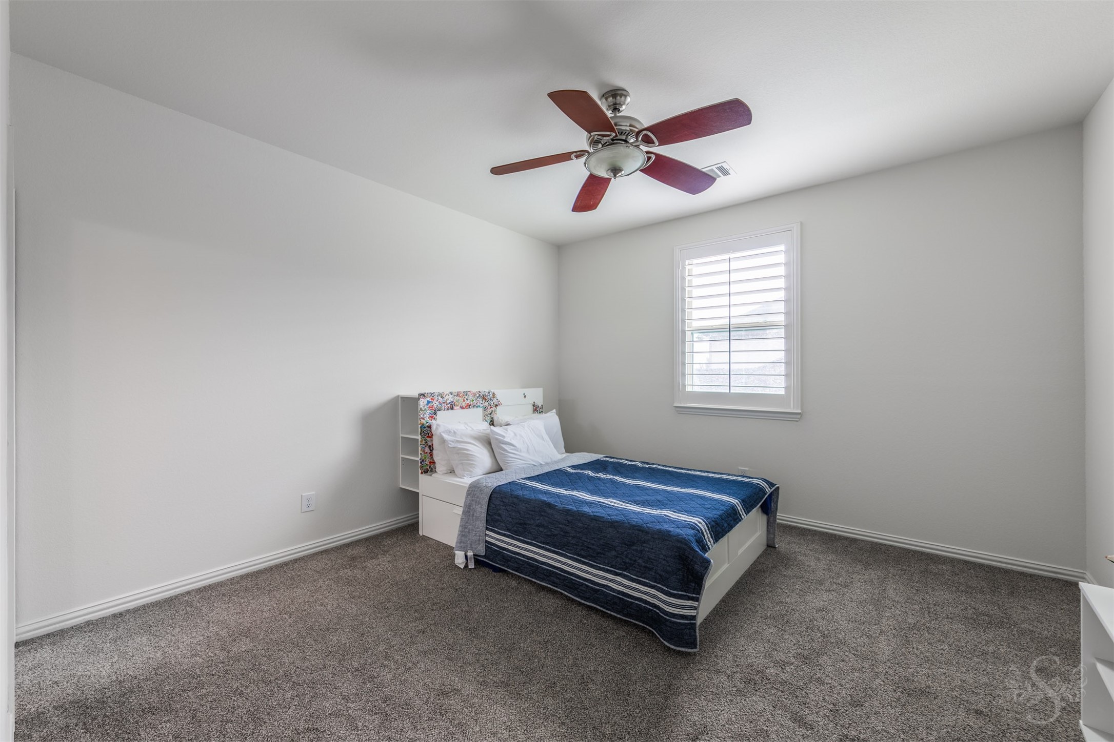 28602 Hoffman Spring Lane Fulshear, TX 77441 - Photo 36 of 49 Well-proportioned secondary bedroom features plush carpeting, a ceiling fan, and plantation shutters for a clean, comfortable setting. The layout easily accommodates full bedroom furnishings along with a desk or study area, and includes access to a private full bath.