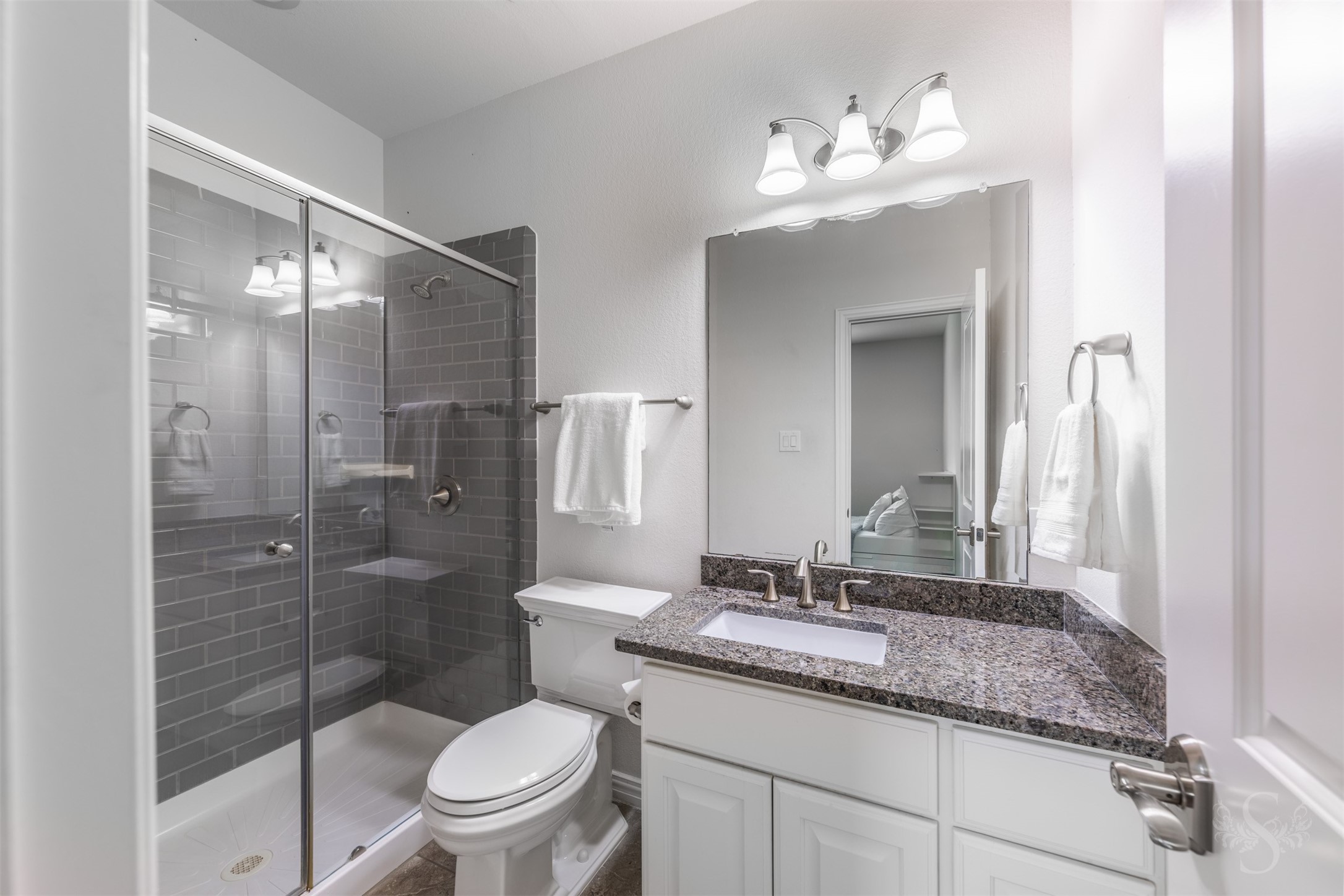 28602 Hoffman Spring Lane Fulshear, TX 77441 - Photo 37 of 49 Each bedroom is complemented by its own full bath featuring an enclosed shower with tile surround, granite countertops, framed mirrors, and polished fixtures. Clean, well-maintained finishes provide a fresh, elevated feel while offering added convenience for daily routines.