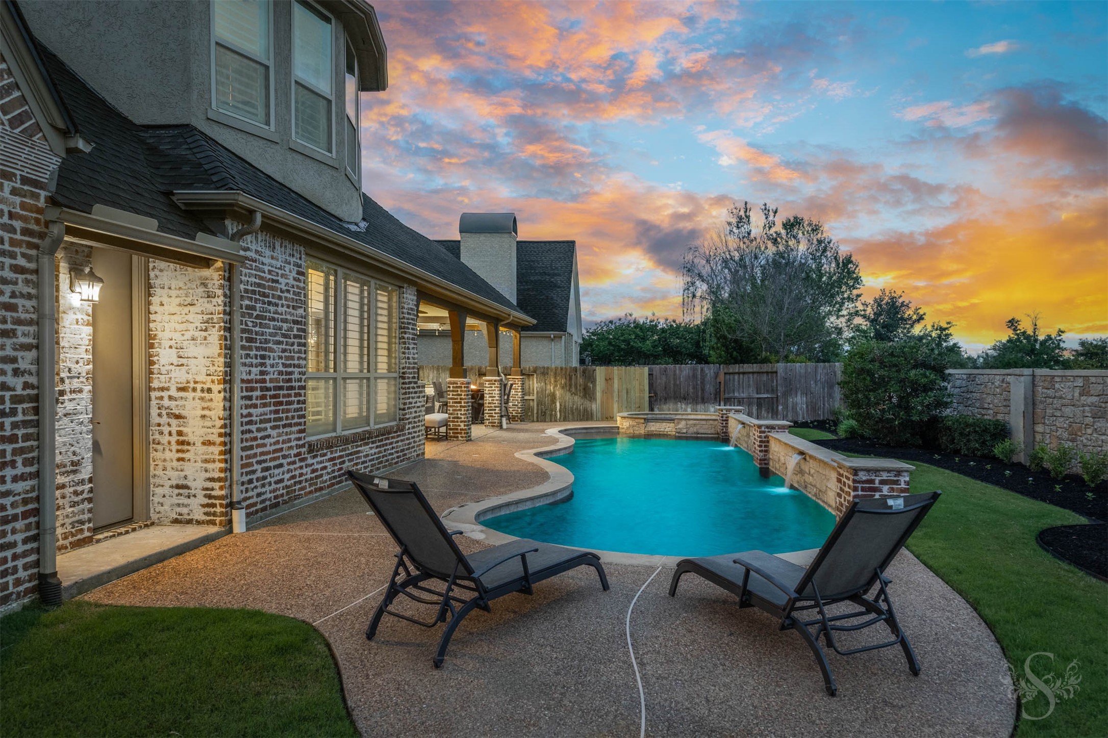 28602 Hoffman Spring Lane Fulshear, TX 77441 - Photo 39 of 49 Private backyard retreat highlights a stunning pool with water features and dedicated lounging areas positioned to take in the setting. Thoughtfully designed hardscaping and green space offer both relaxation and room to spread out.