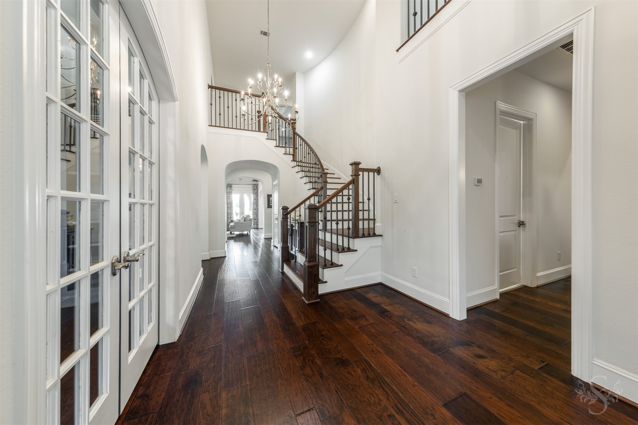 28602 Hoffman Spring Lane Fulshear, TX 77441 - Photo 4 of 49 Impressive gallery-style entry opens to the heart of the home, framed by a dramatic curved staircase and soaring ceilings that create an immediate sense of scale. The private study is positioned just off the entry, while an upper-level catwalk adds architectural interest and overlooks the space below.
